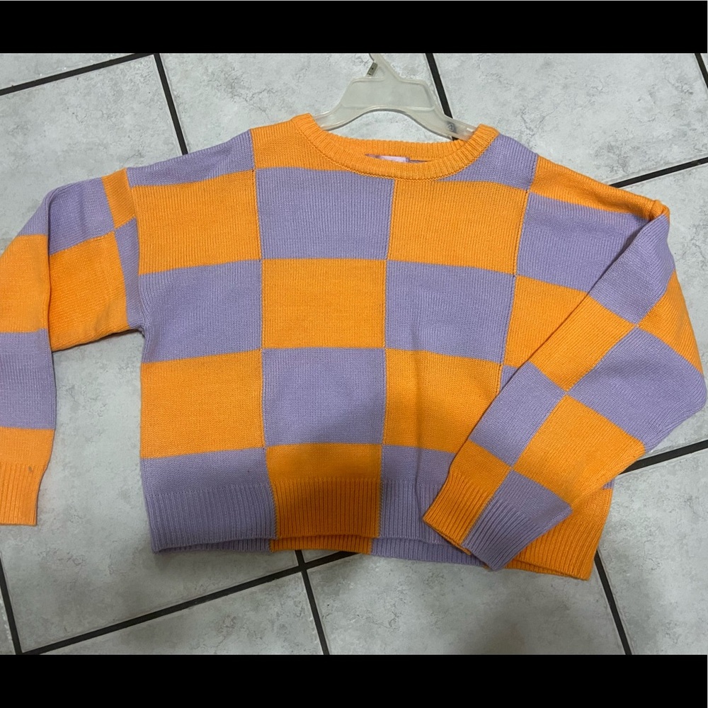 Long sleeve, slightly cropped, purple and orange shirt.